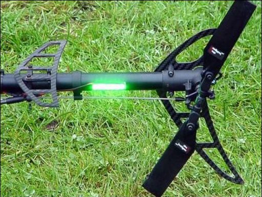 RC Heli mit LED Positionslichter Schwarzes Gerät mit grüner LED-Anzeige auf grünem Rasen.
